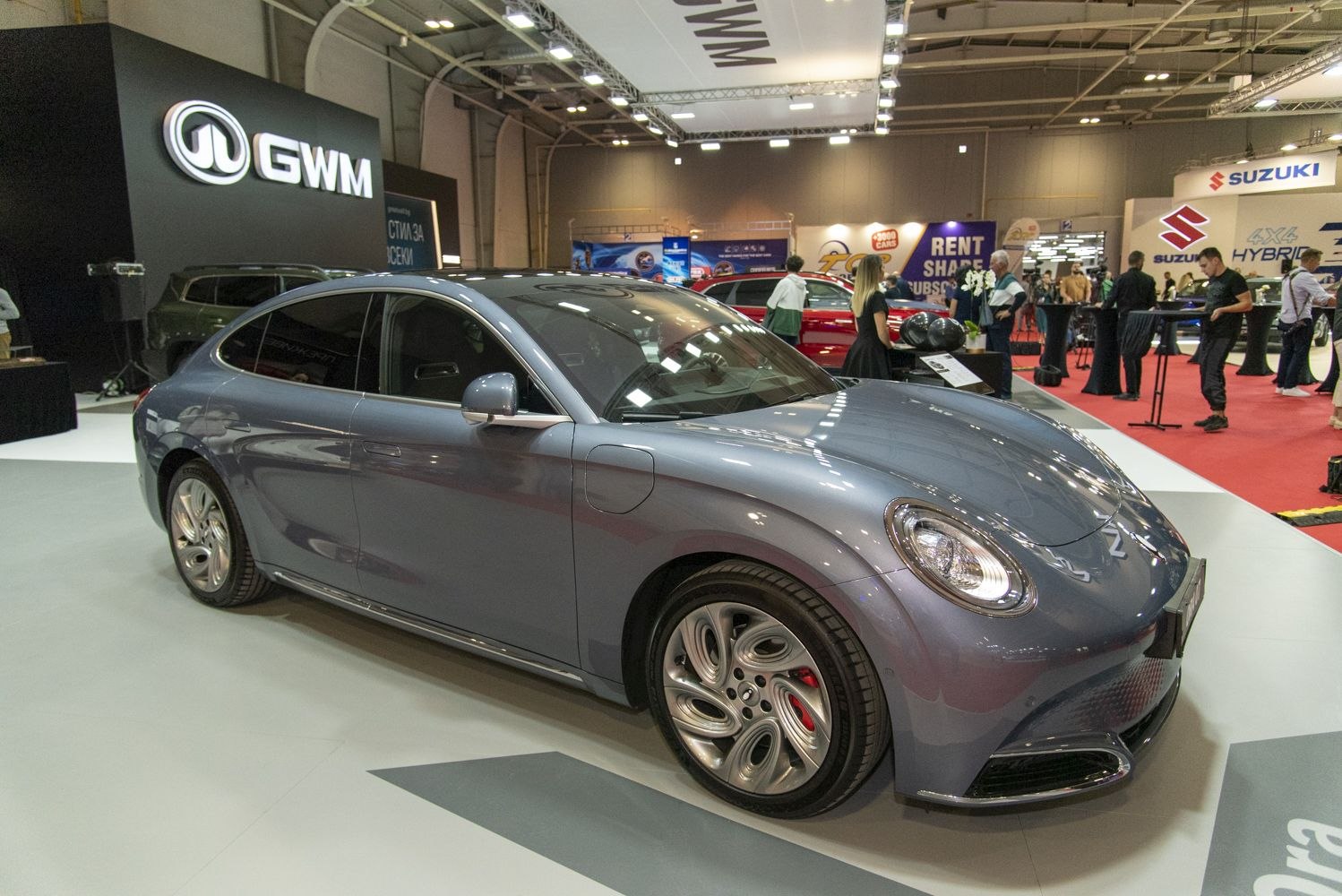 Electric sedan with retro round headlights and aerodynamic multi-hole wheels