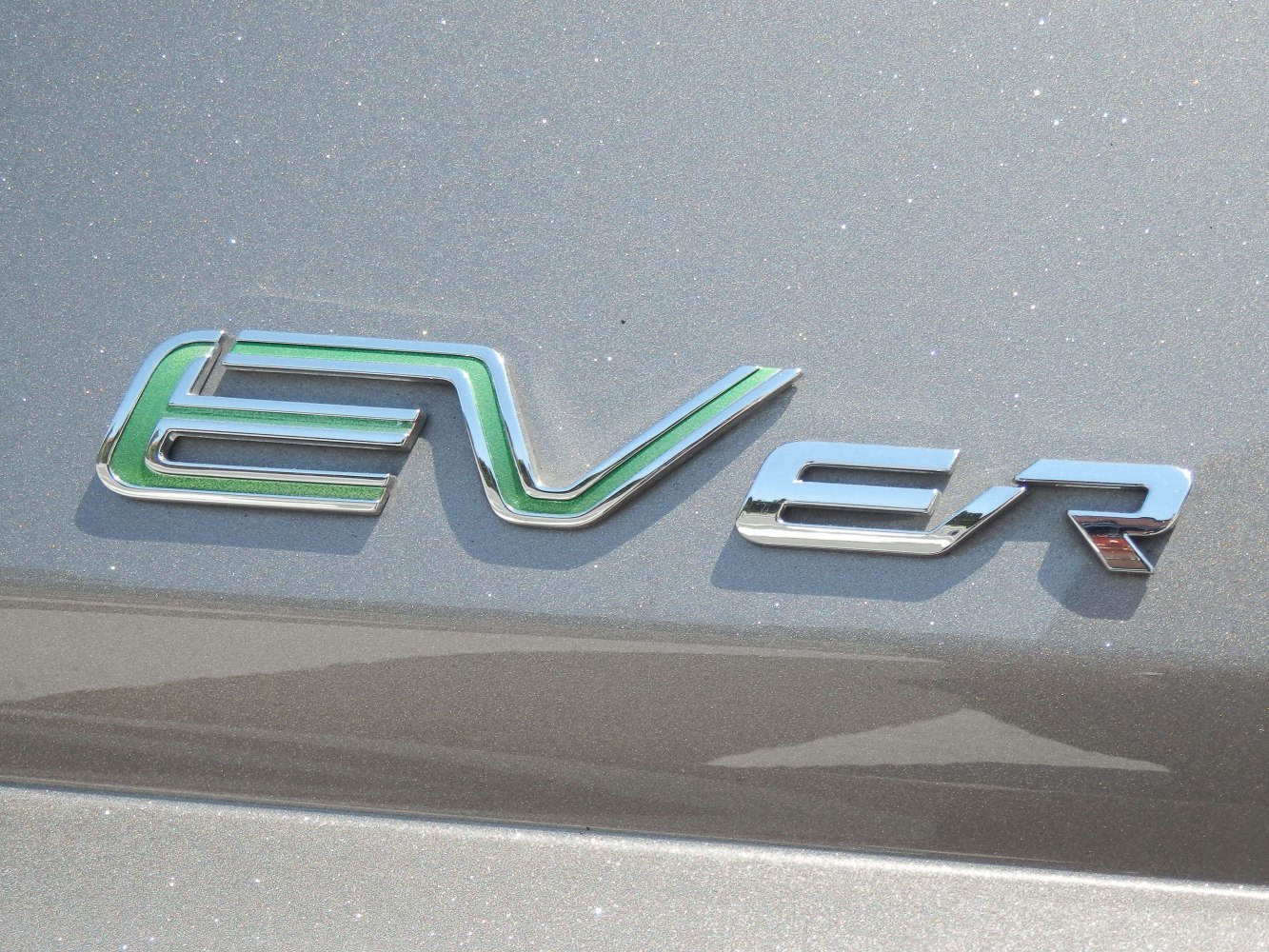 Close-up of EV ER badge emblem with green accent on metallic surface