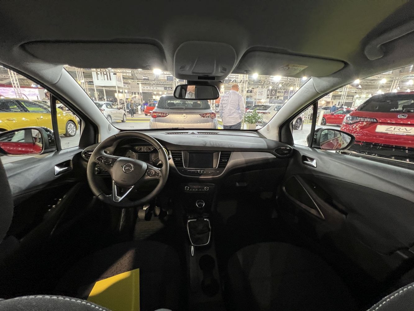 Steering wheel, dashboard, and central infotainment screen inside a vehicle cabin.
