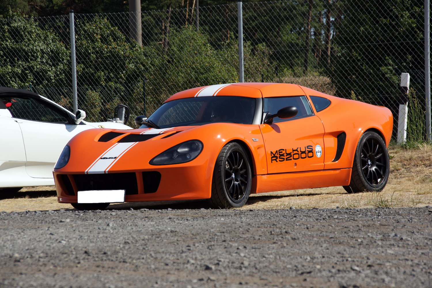 Orange sports coupe with white racing stripes and black rims