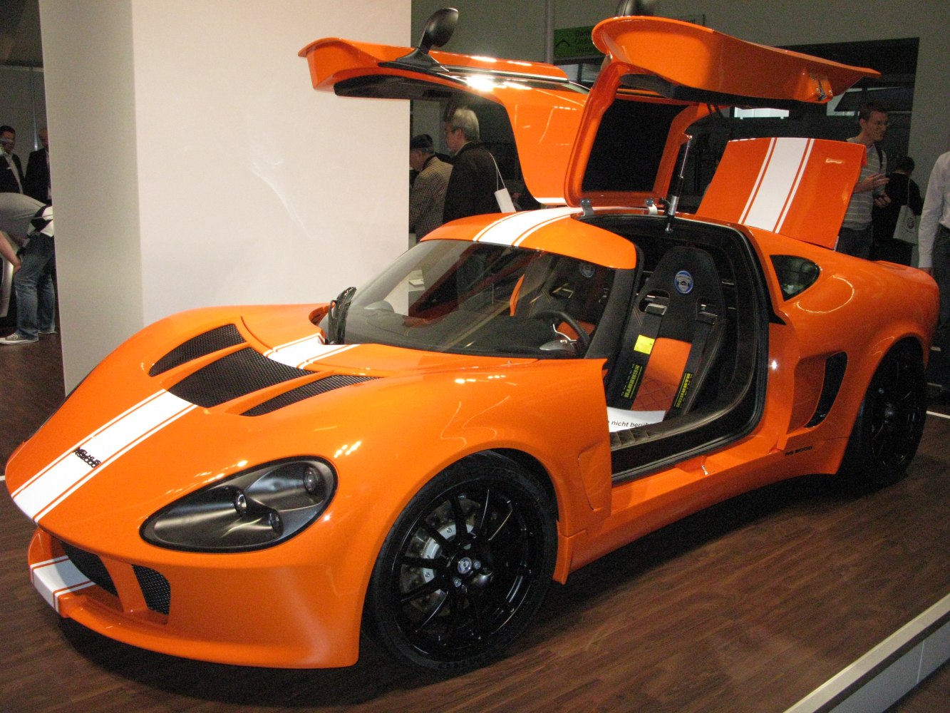 Orange sports car with gullwing doors and racing seats