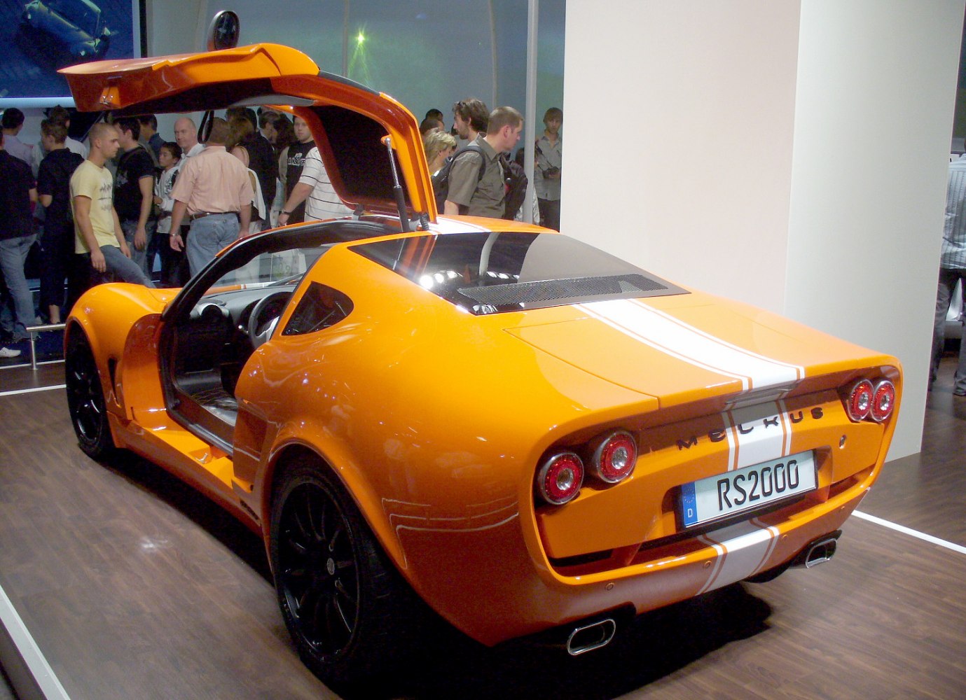 Orange sports coupe with gullwing door and distinctive rear design