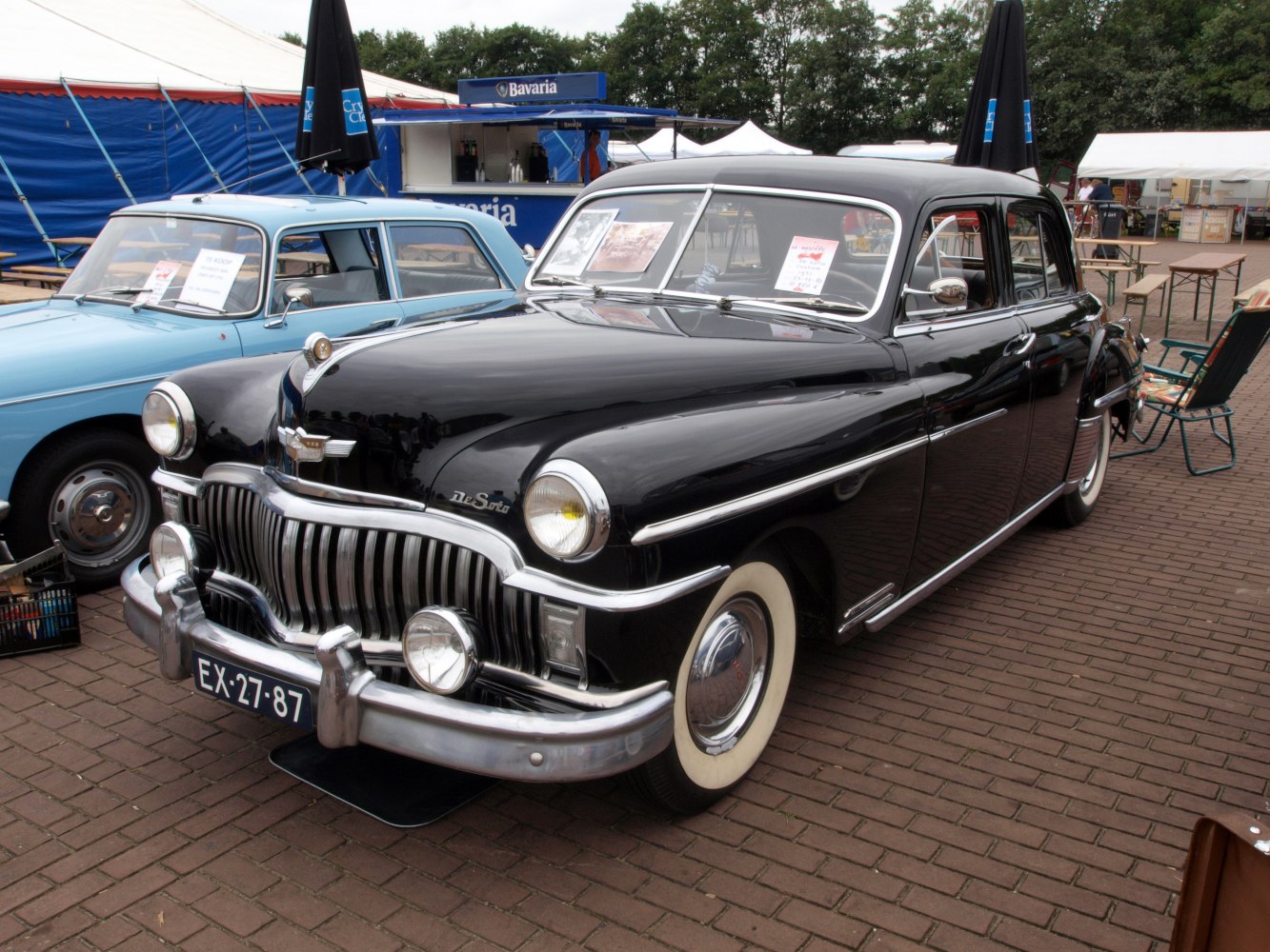 Vintage front grille, chrome detailing, whitewall tires on classic sedan