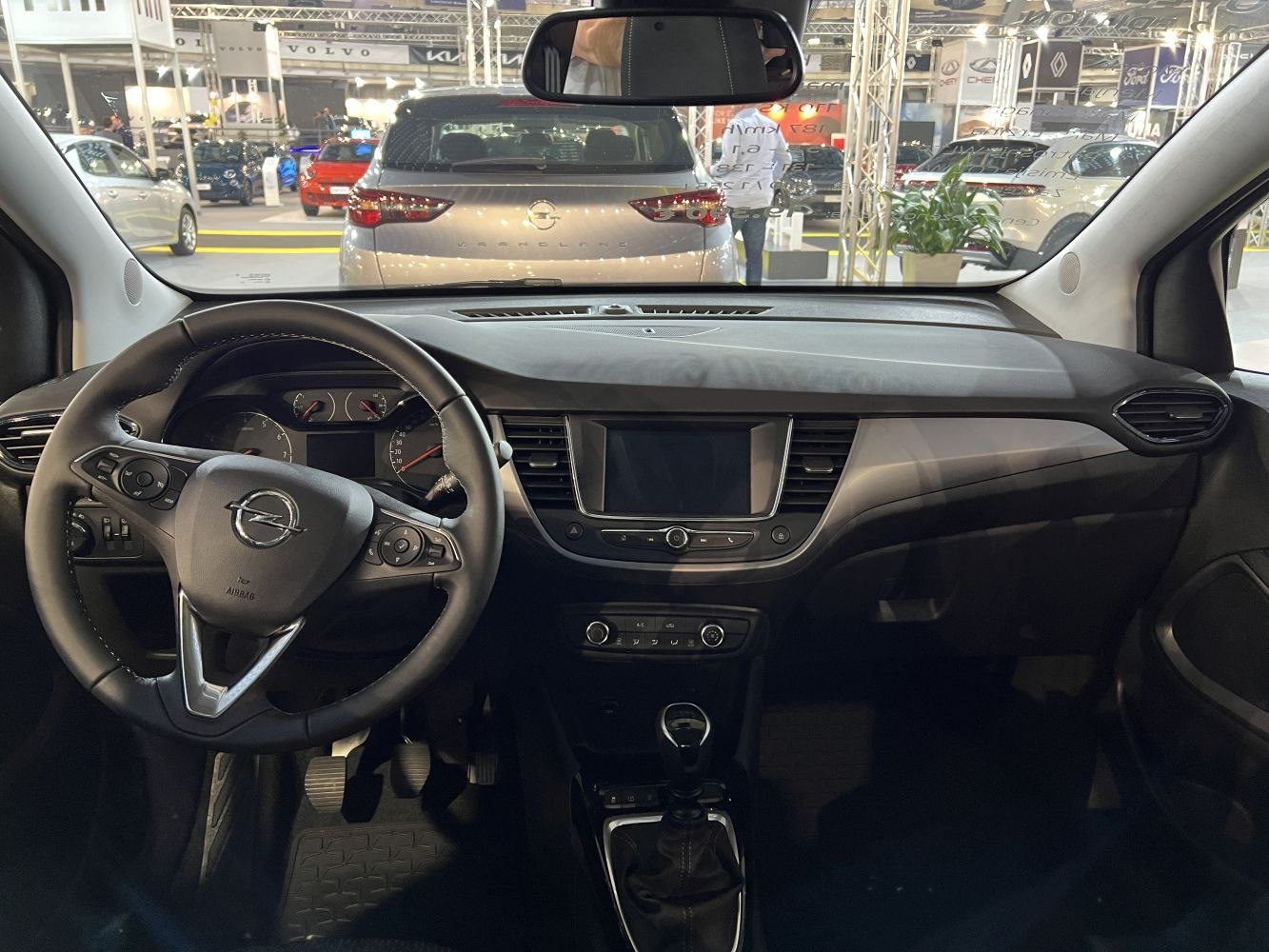 Dashboard and steering wheel interior featuring infotainment and manual gear shift