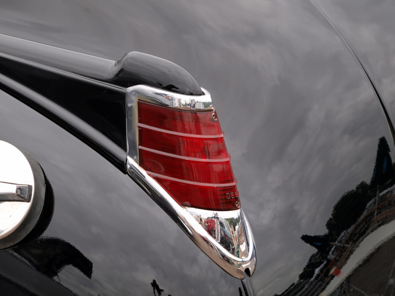 Close-up of vintage 1949 taillight with chrome trim on black body