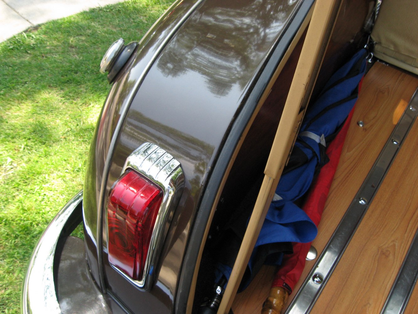 Rear tail light and wood-trimmed cargo area with stored umbrellas