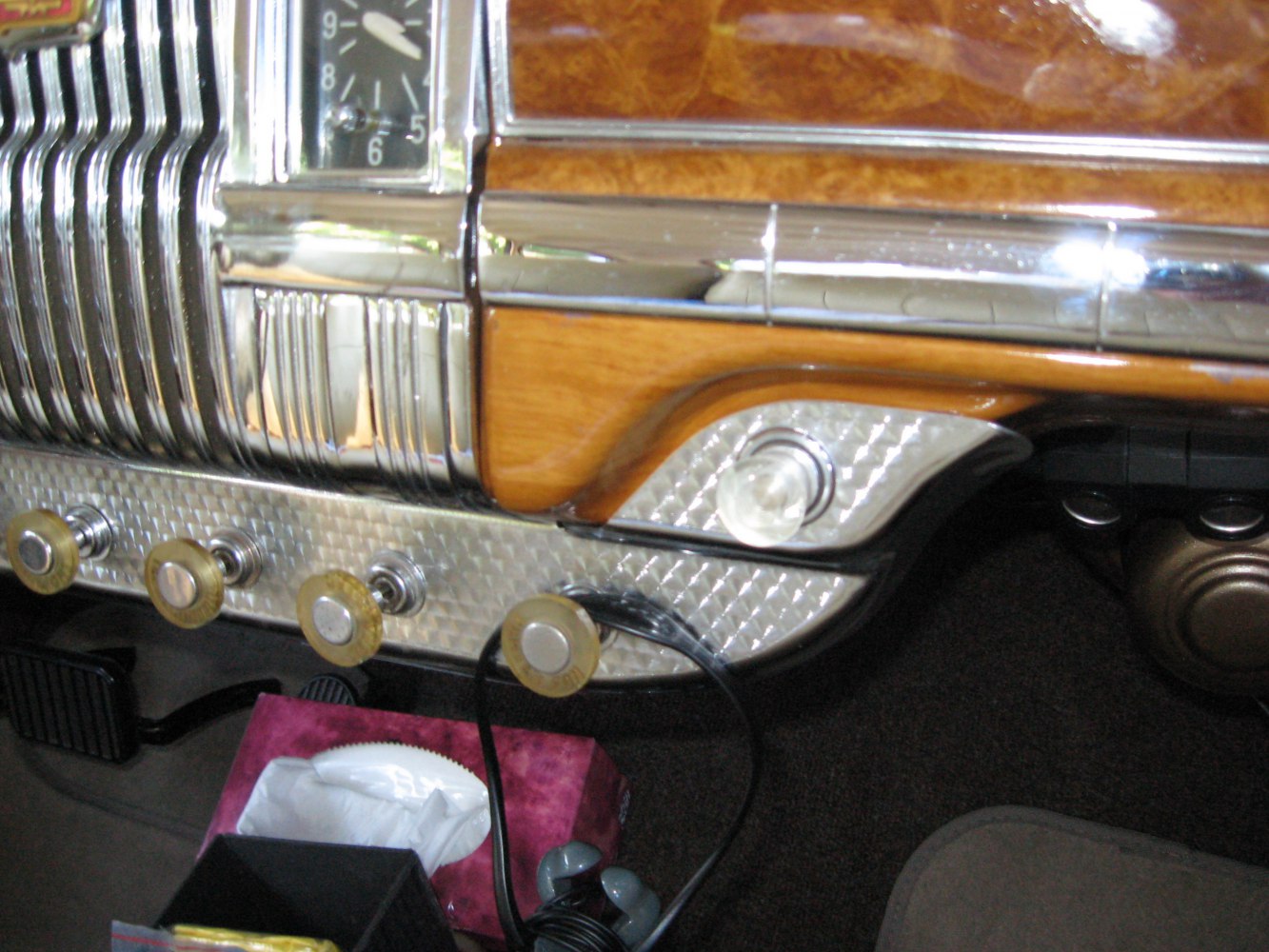 Chrome dashboard section with built-in clock and four vintage knobs