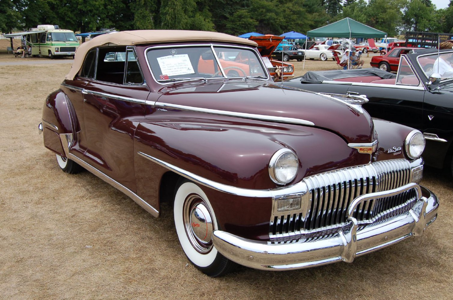 Classic 1940s convertible coupe with chrome grille and whitewall tires