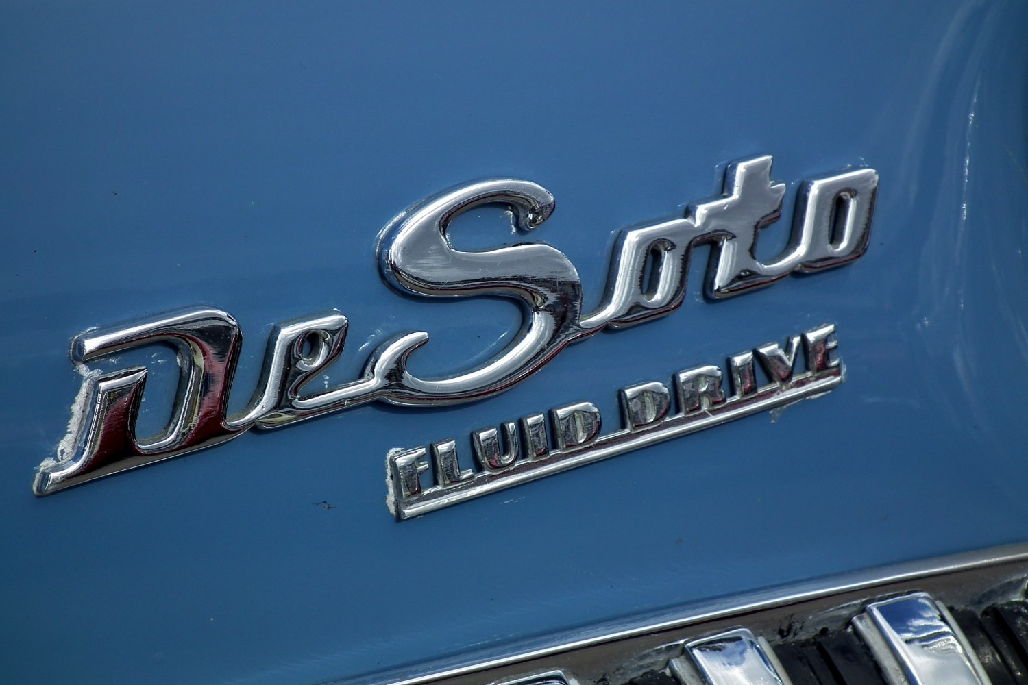 Chrome DeSoto emblem and Fluid Drive badge on blue surface