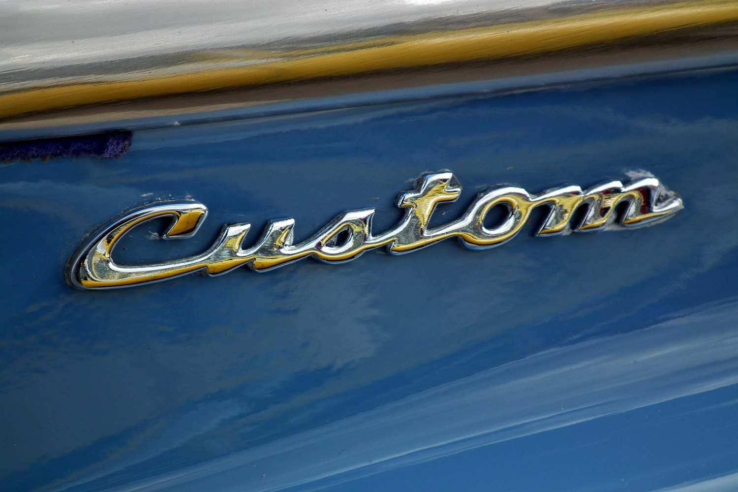 Chrome Custom script emblem on blue painted surface