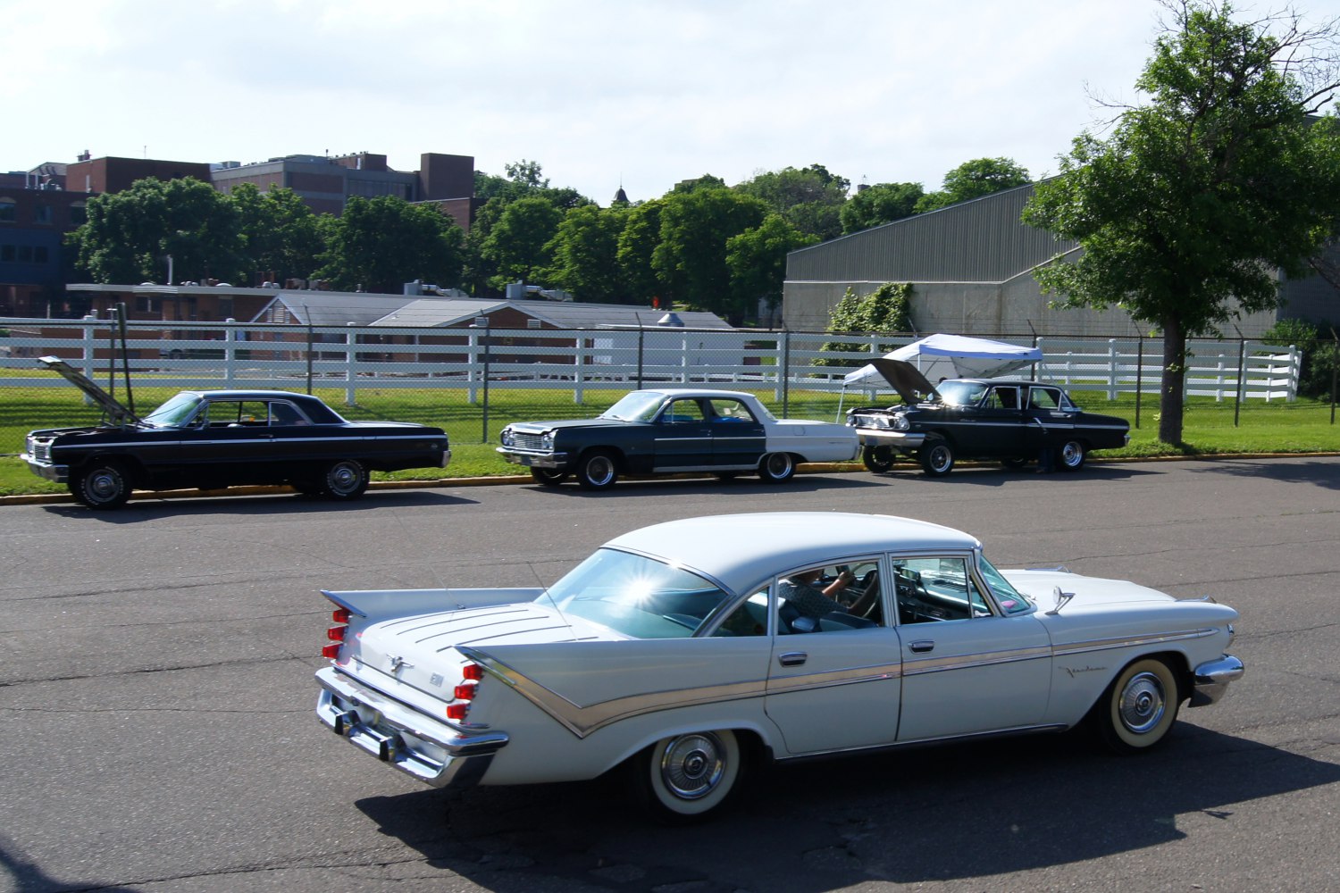 Vintage four-door sedan with large tail fins and chrome accents