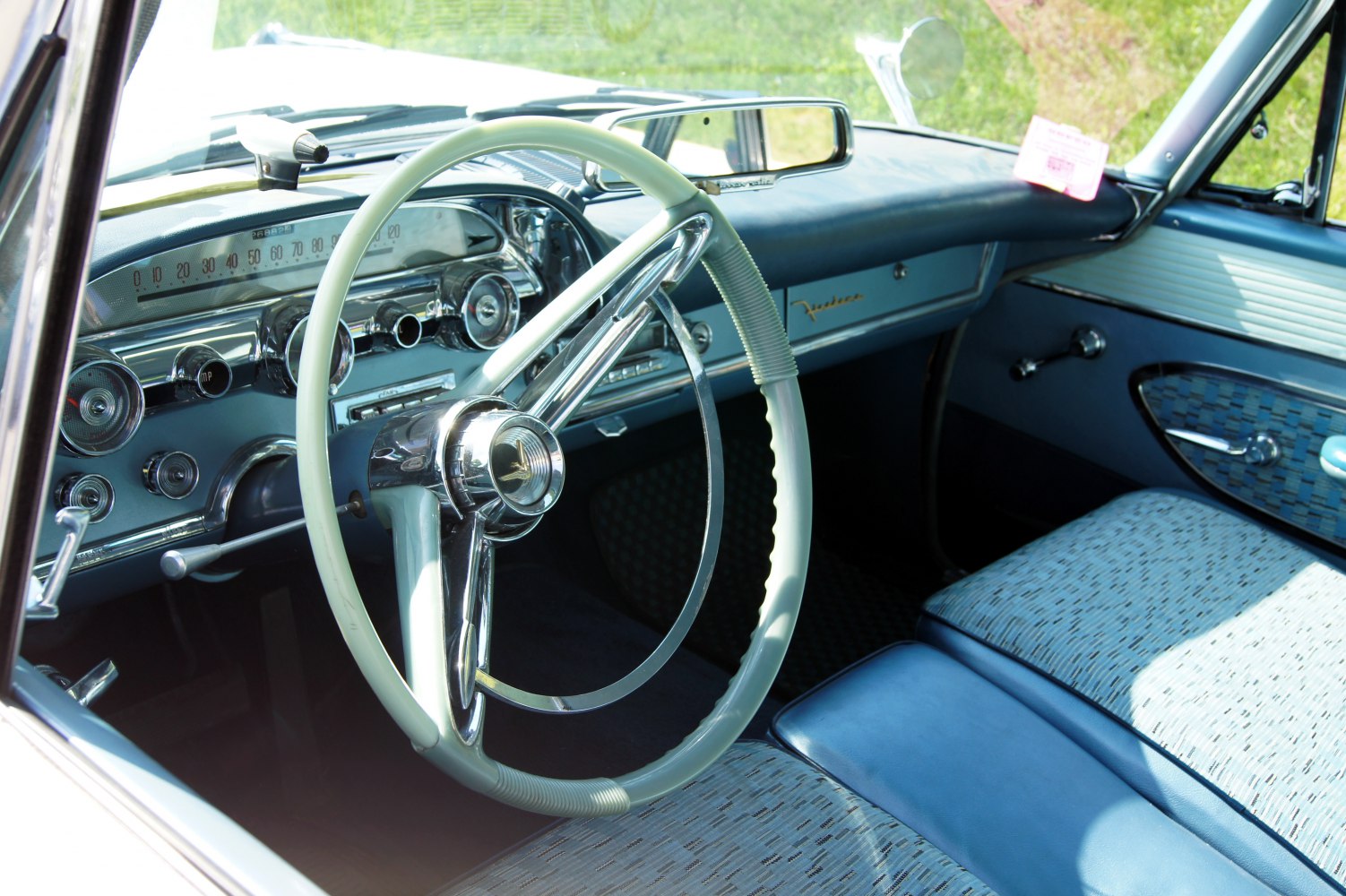 Retro 1950s-style steering wheel and dashboard with vintage controls and upholstery