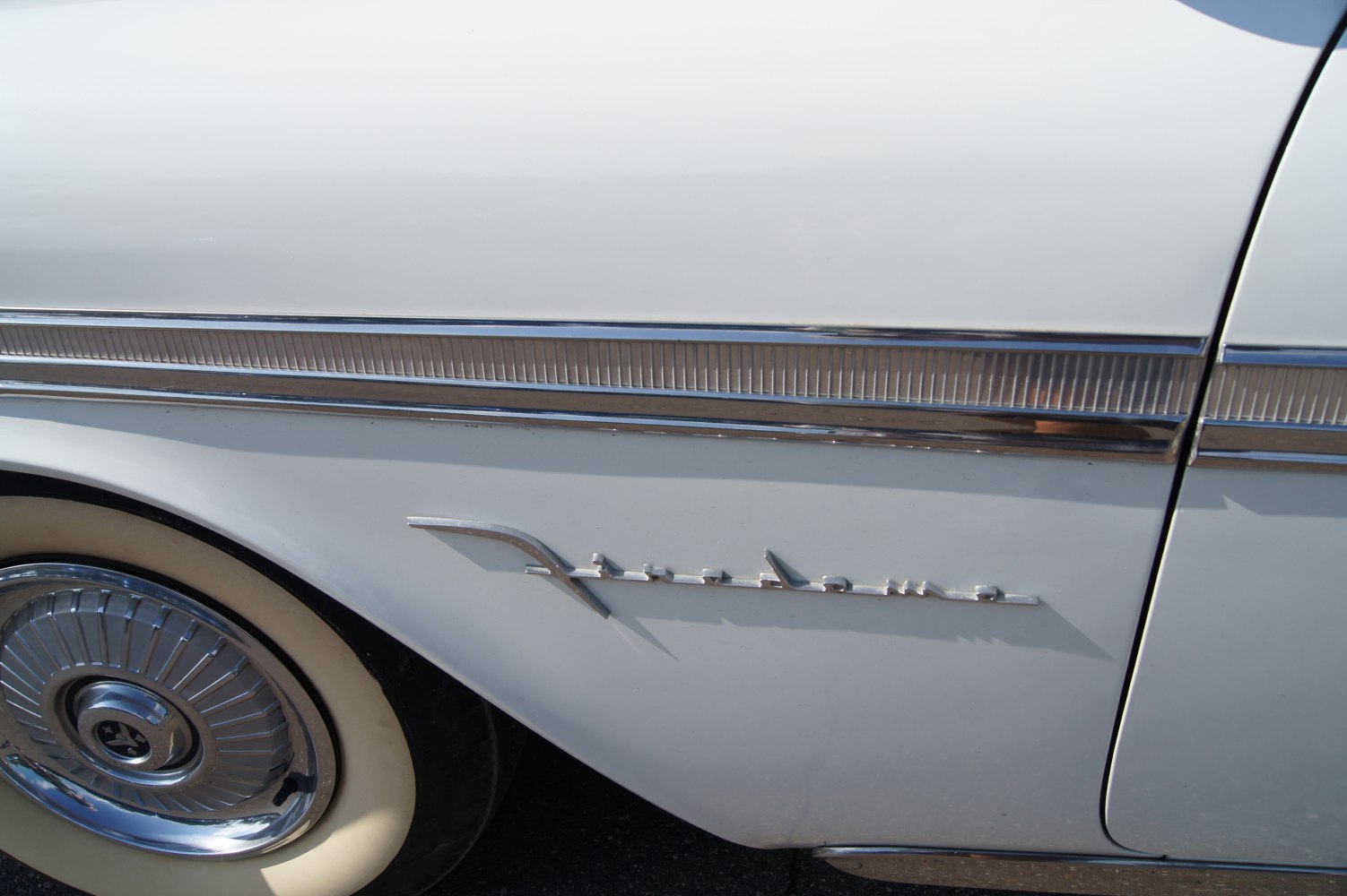 Vintage side trim and classic hubcap on a whitewall tire