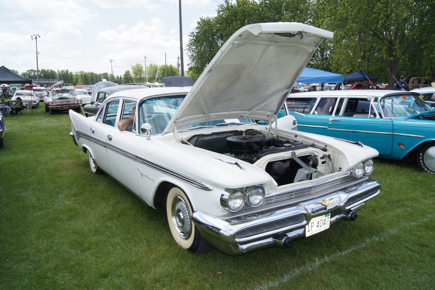 Four-door sedan with dual headlights and open hood