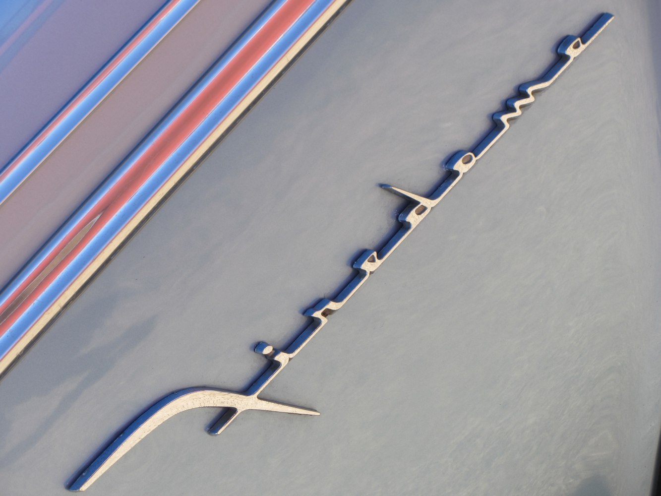 Close-up of vintage car emblem and chrome trim