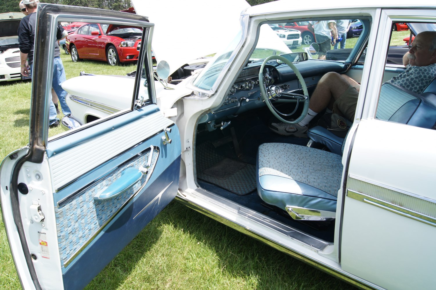Open driver door with blue upholstery and steering wheel visible