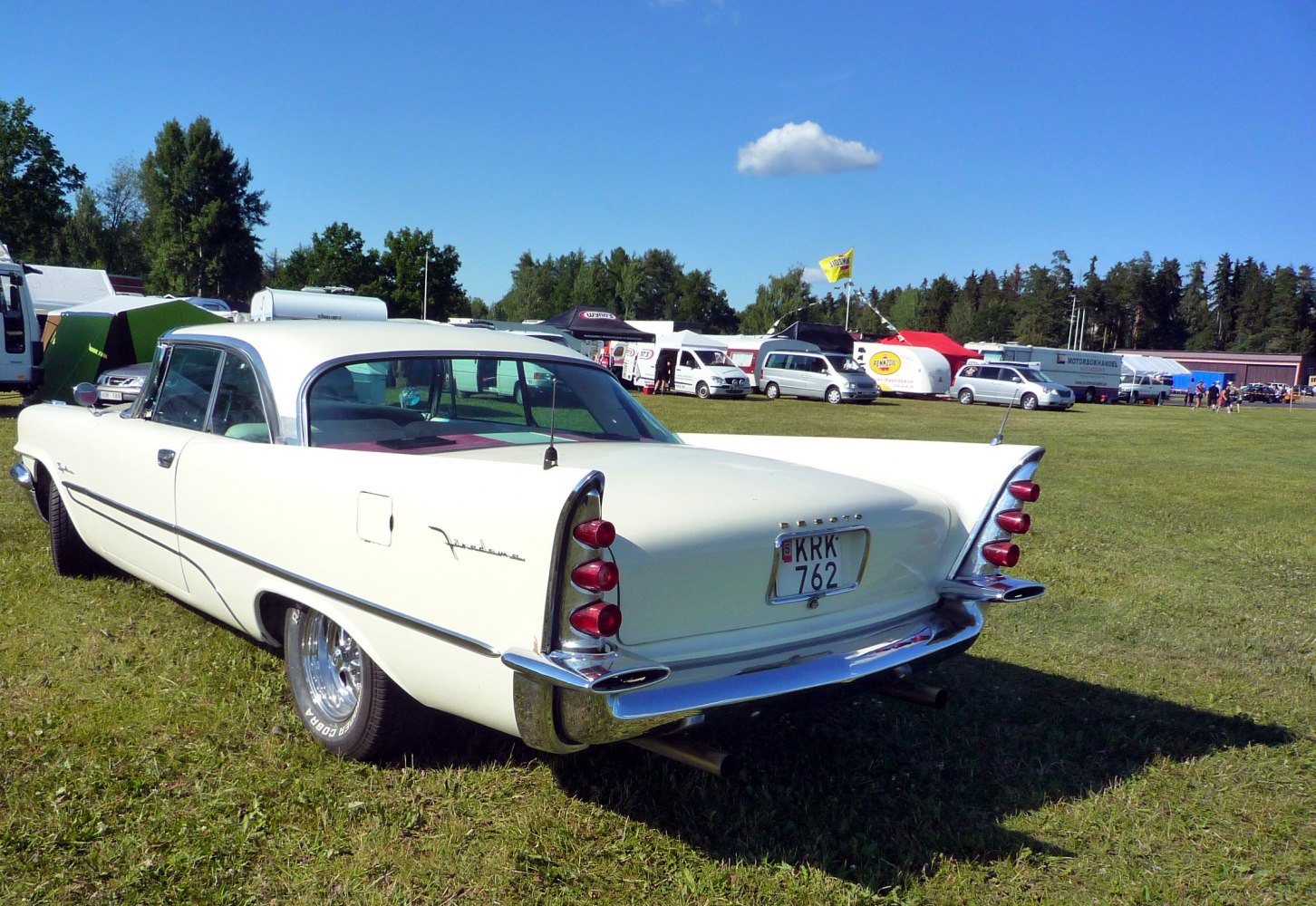 Rear side view of a vintage two-door coupe with prominent tailfins and quad tail lights