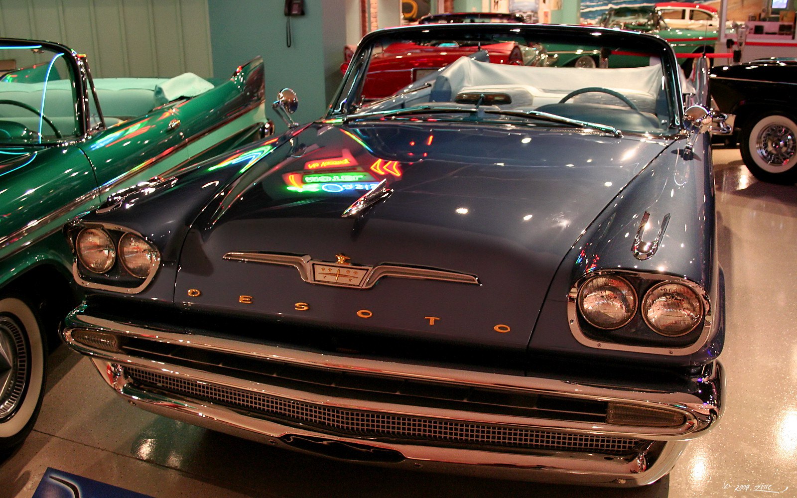 Dual headlights and chrome bumper on a vintage 1950s convertible front.
