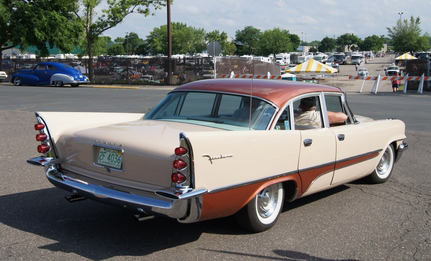 Rear view of classic four-door sedan with triple vertical tail lights and two-tone paint.