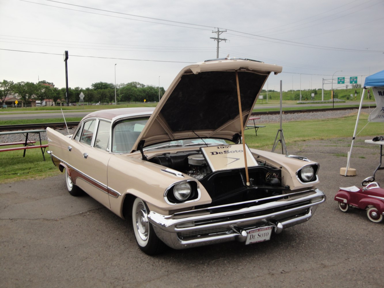 Mid-century four-door sedan with open hood and distinctive front headlights.