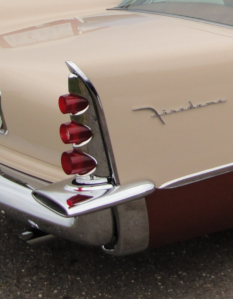 Triple bullet taillights integrated in a large chrome tailfin with classic 1950s styling