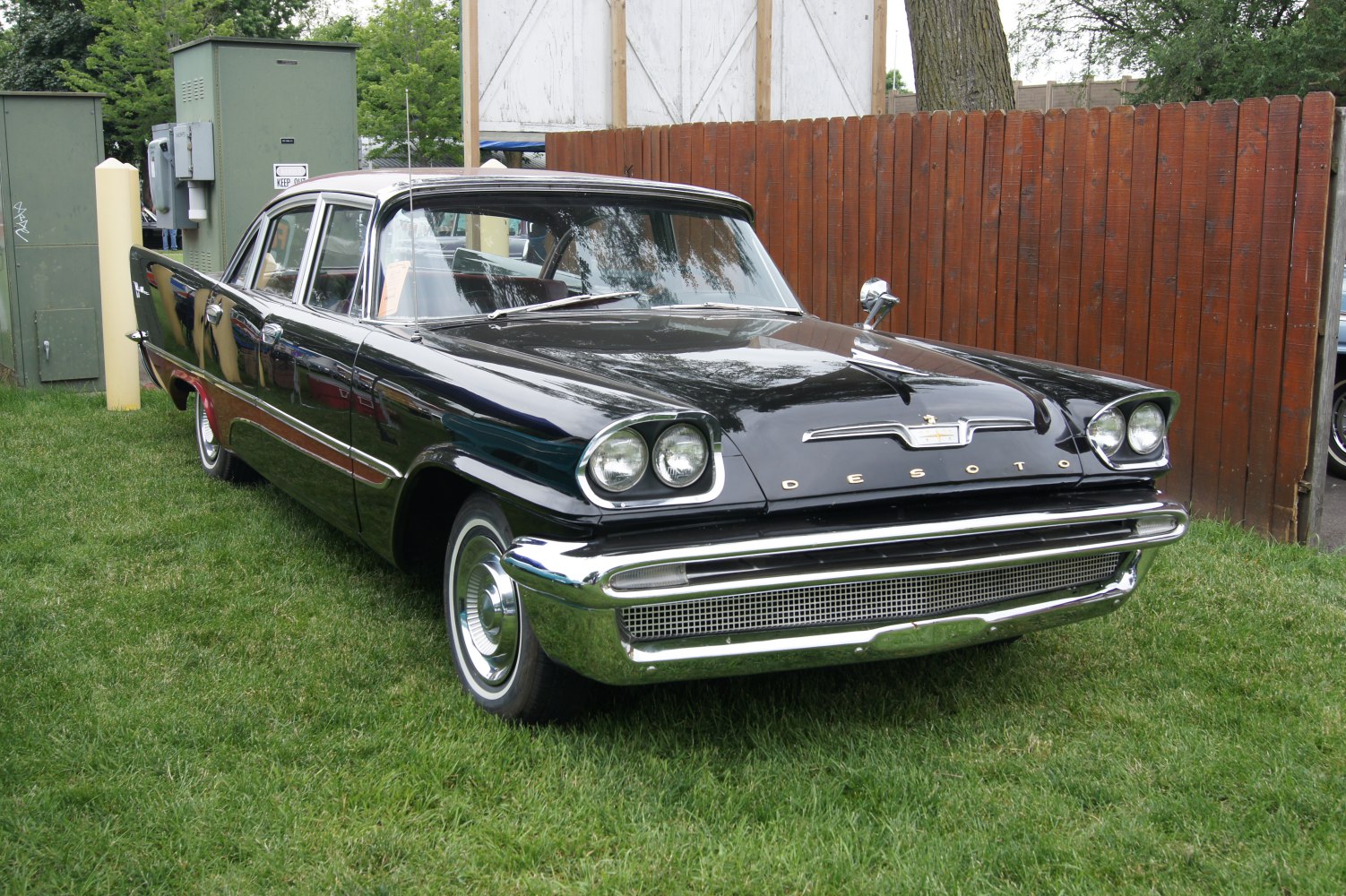 Dual round headlights and shiny chrome grille on vintage four-door sedan