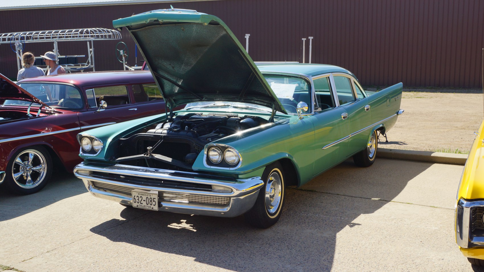 Classic four-door sedan with dual headlights and open hood.