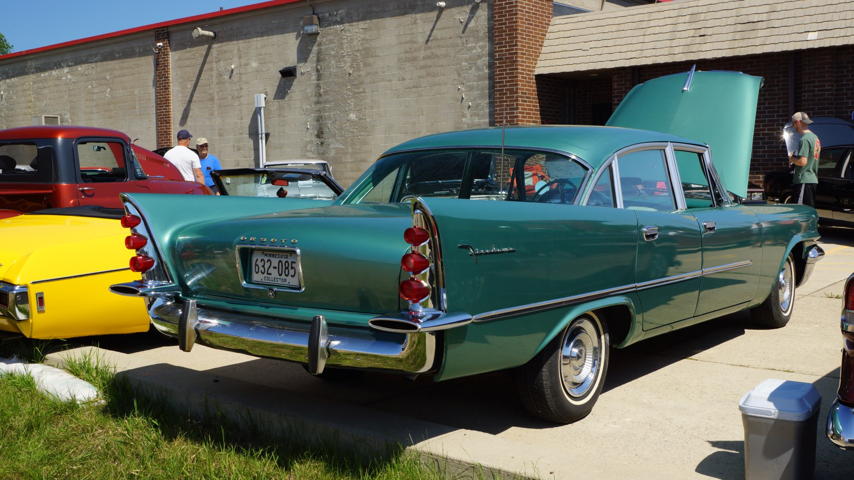 Retro four-door sedan with prominent tailfin and triple red taillights.