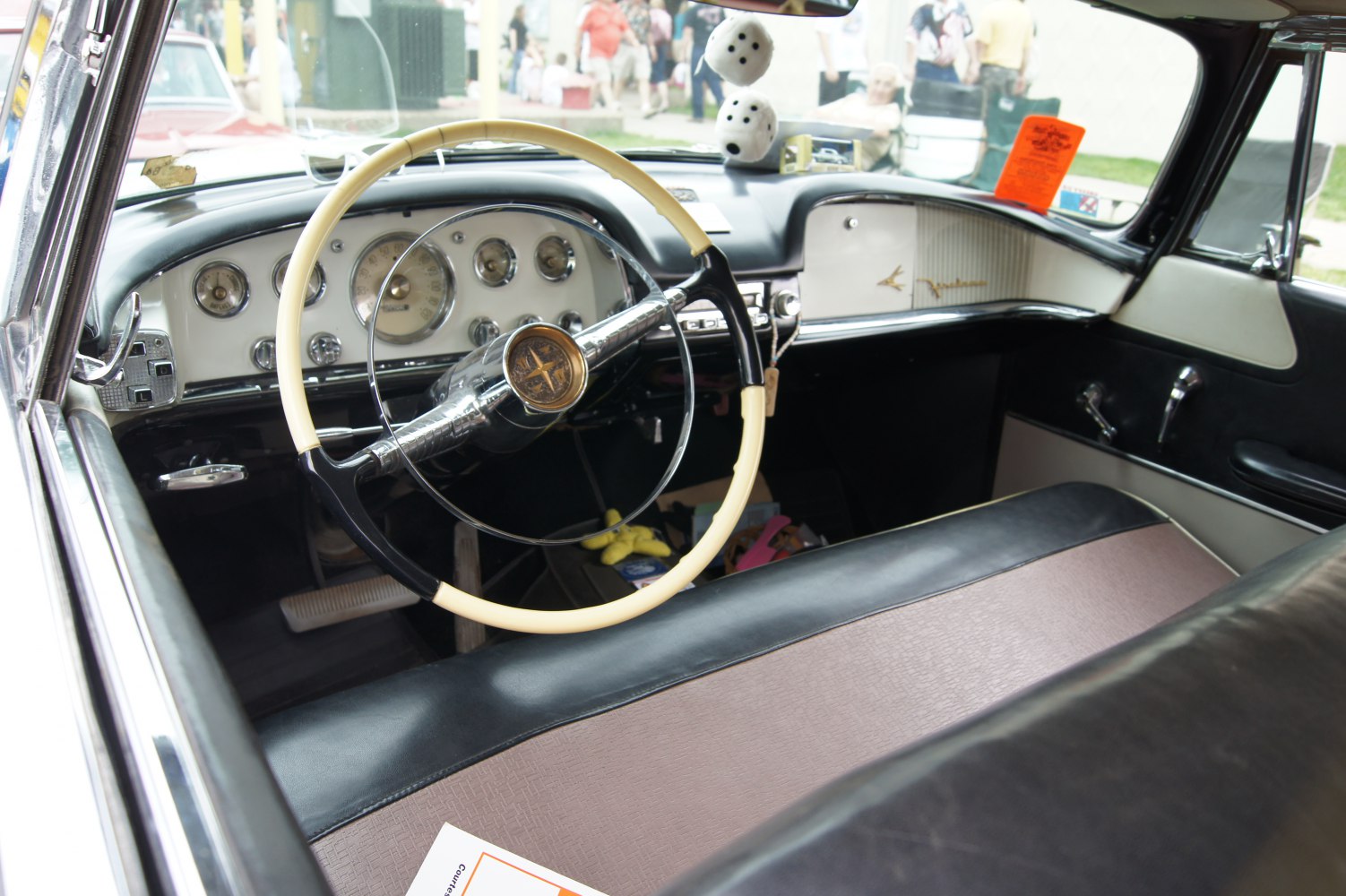 Vintage steering wheel and classic dashboard with gauges and two-tone upholstery
