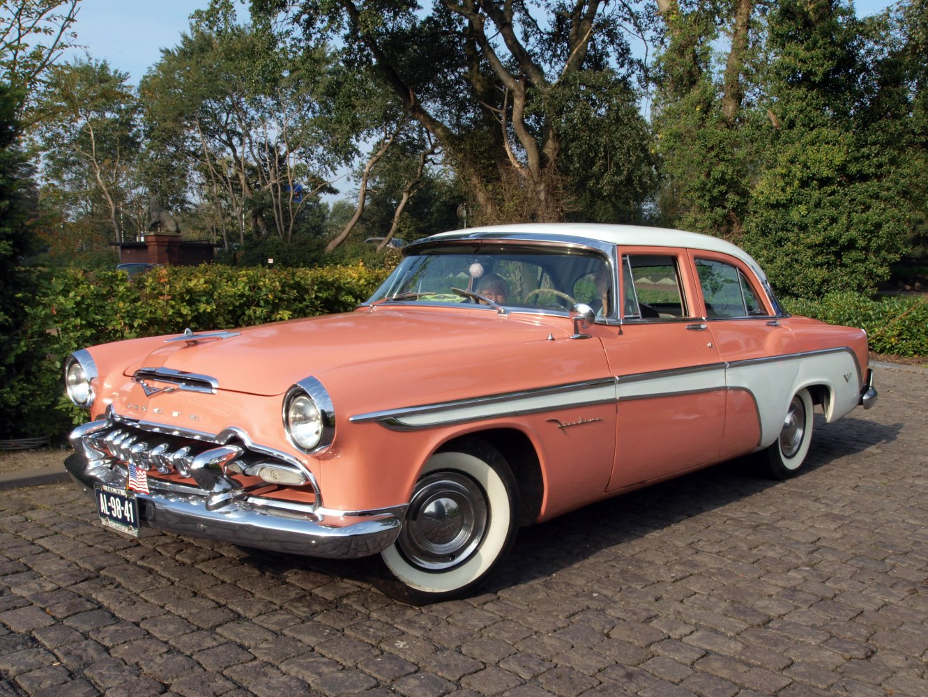 Front and side of 1950s classic car with chrome grille and whitewall tires