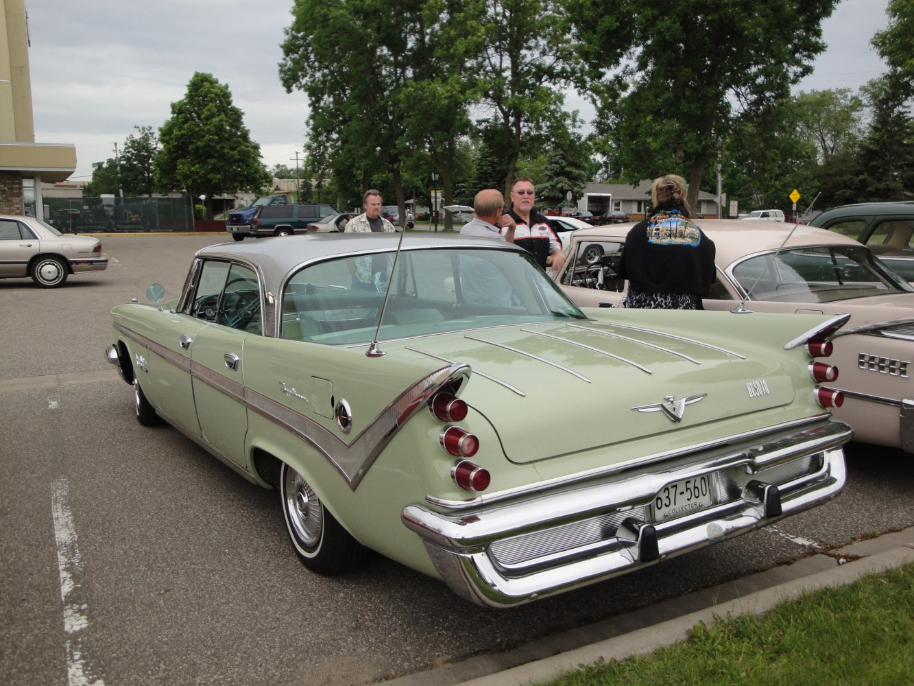 Triple tail lights, prominent tailfins, and chrome rear bumper on classic 1959 sedan.