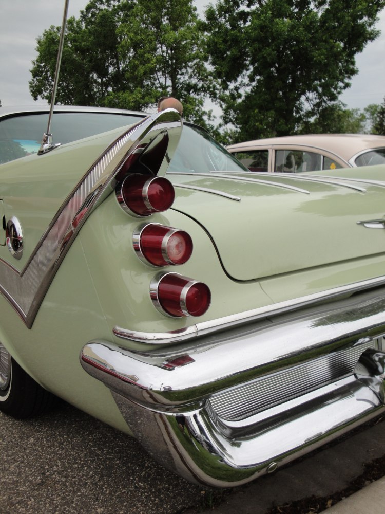 Triple round tail lights and large chrome rear bumper from a classic 1950s car