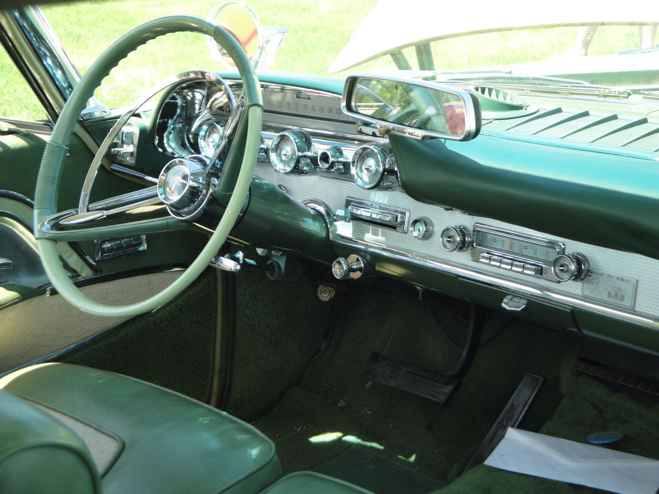 Vintage green steering wheel and classic 1950s dashboard instruments and controls