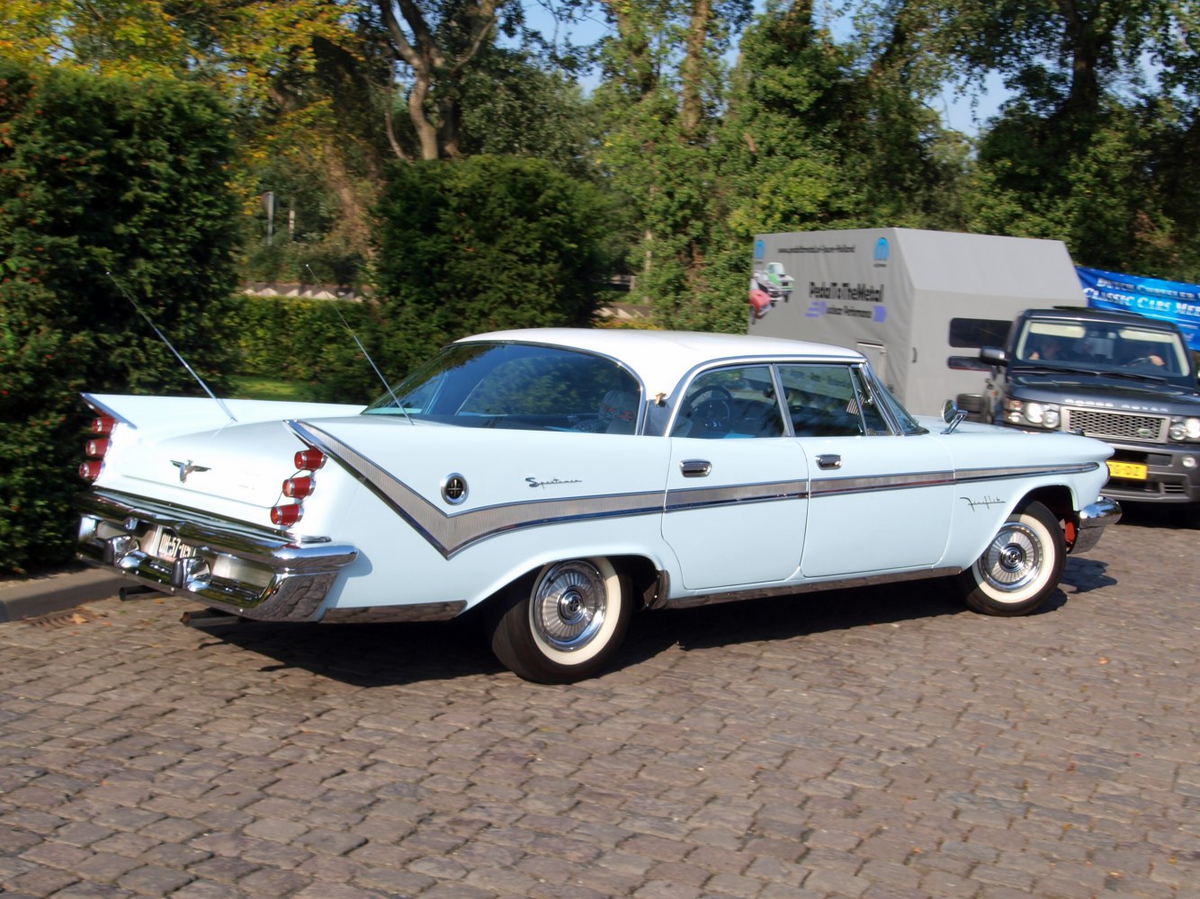 Classic 1950s sedan with prominent tail fins and whitewall tires