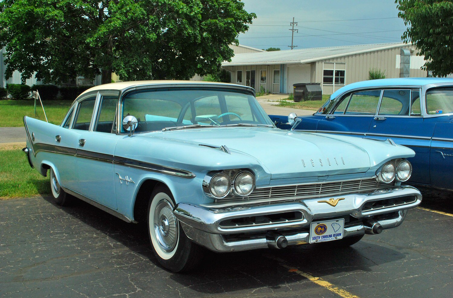 Dual round headlights, extensive chrome trim, fin tail design on full-size sedan