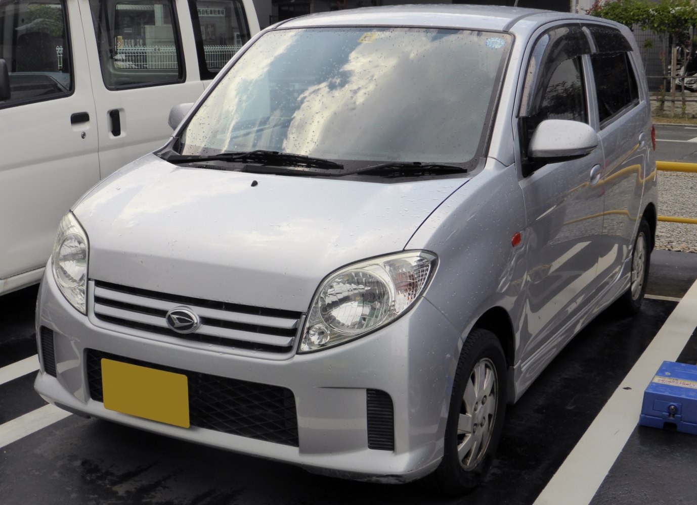 Compact silver kei car front with rounded headlights and simple grille