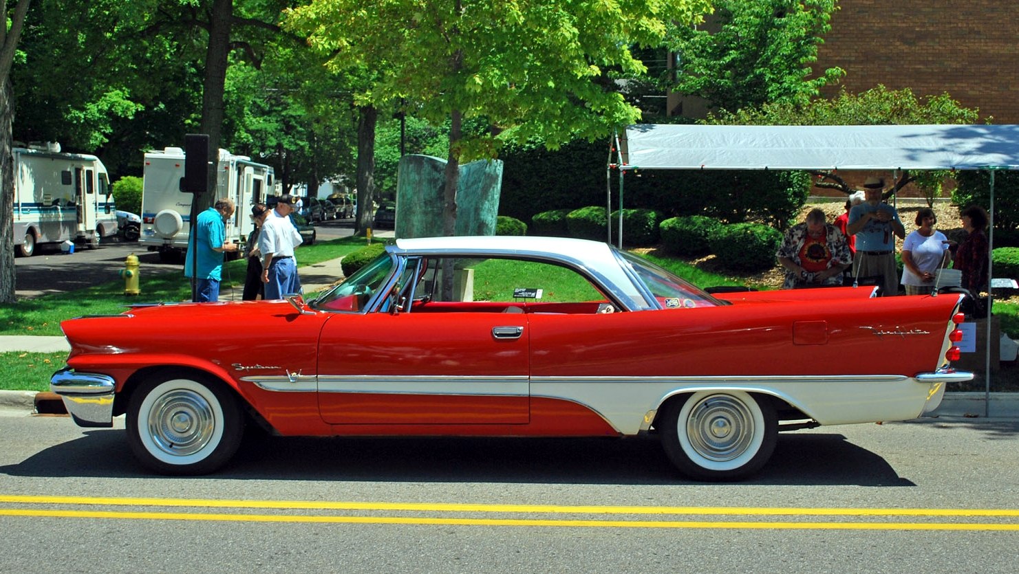 Vintage two-door coupe with prominent tailfins and red-white paint scheme