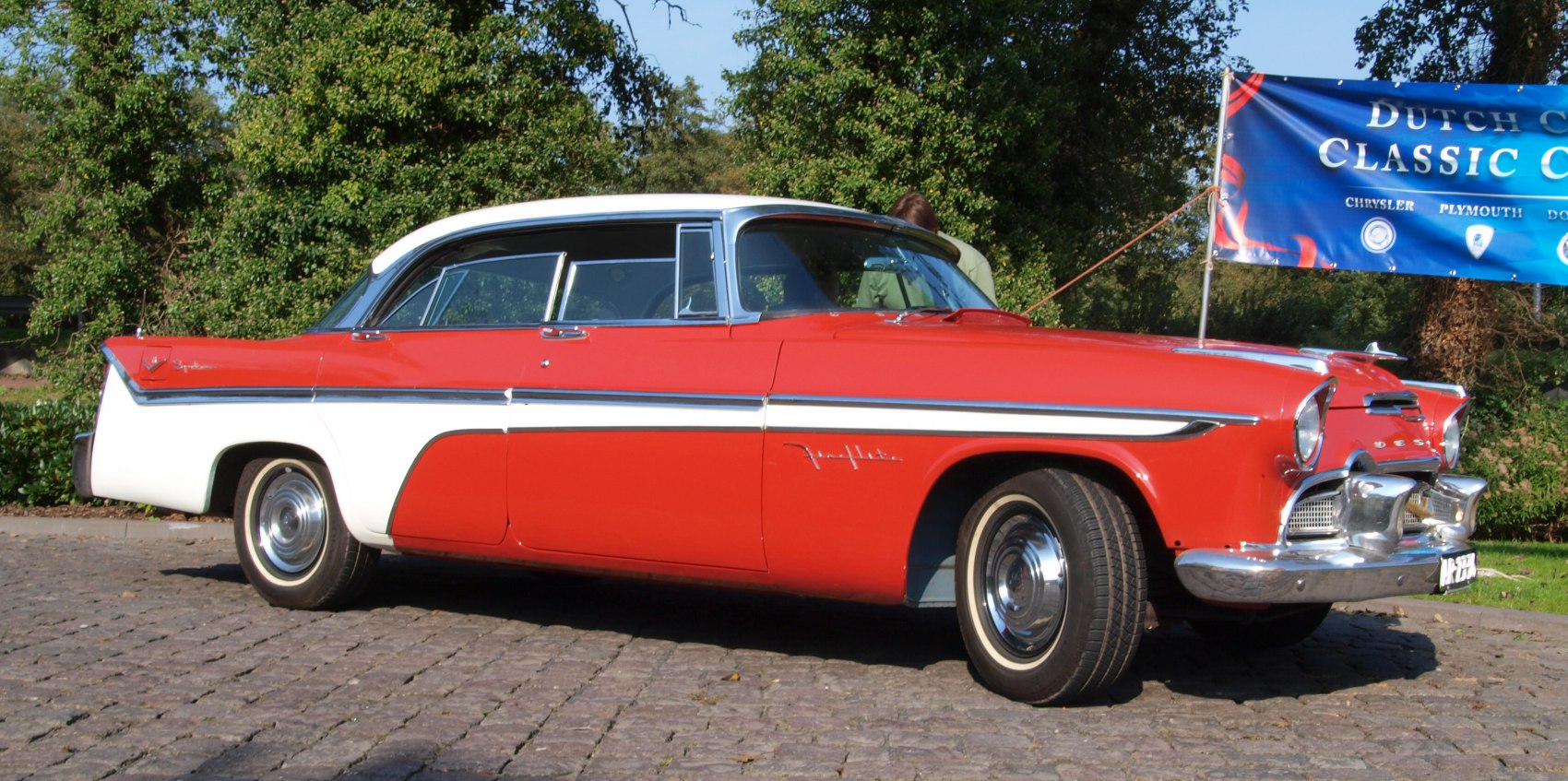 Two-tone four-door sedan with chrome accent and vintage styling