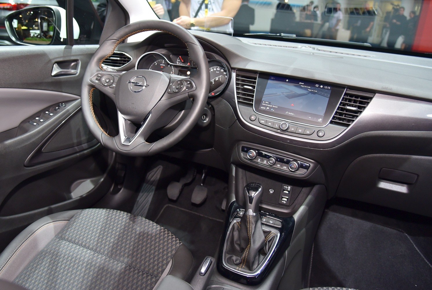 Steering wheel, touchscreen infotainment, automatic gear shifter, and car interior dashboard.