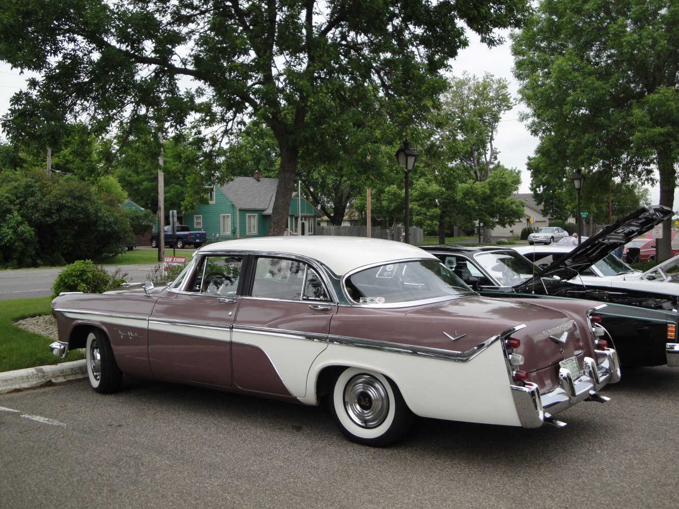 Two-tone vintage four-door sedan with tailfins and whitewall tires