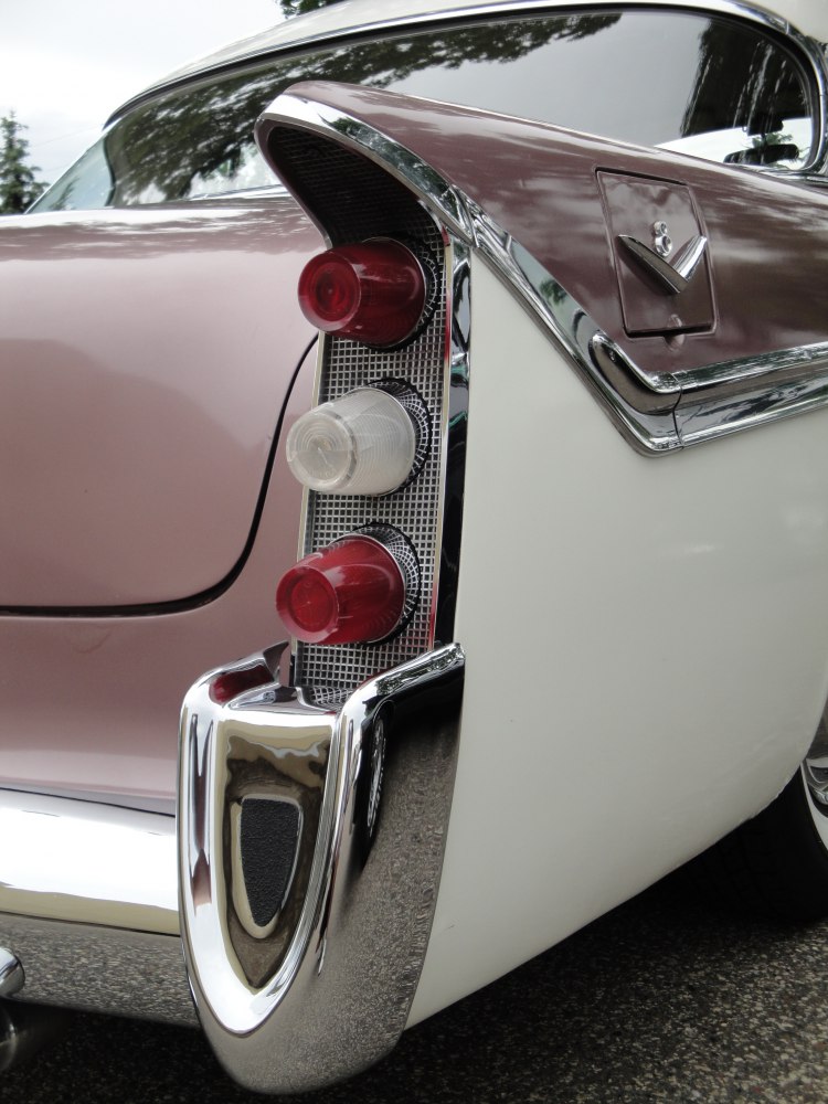 Tri-color tail light with chrome trim on a vintage four-door sedan.