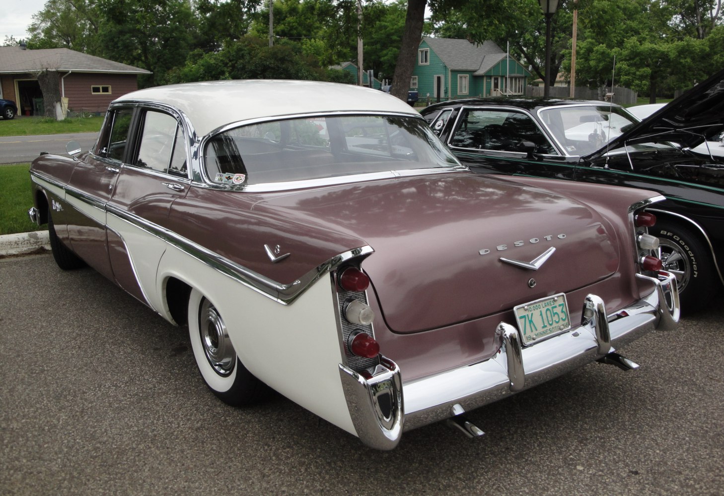 Vintage car rear with tail fins, vertical taillights, and chrome bumper.