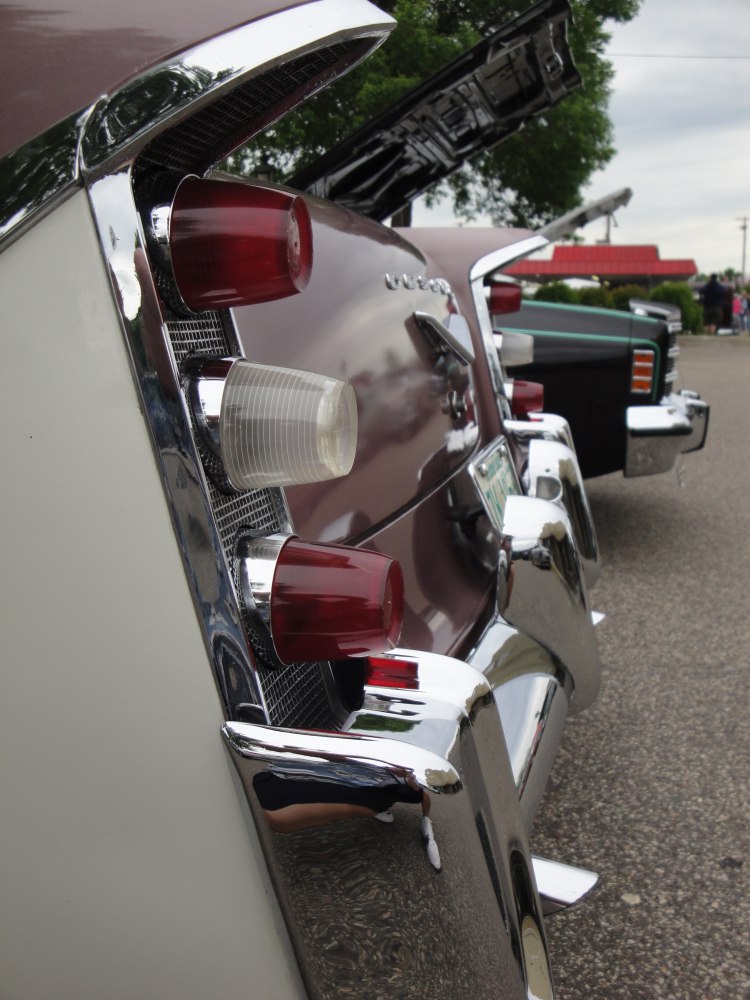 Triple tail lights and chrome rear bumper on a vintage sedan