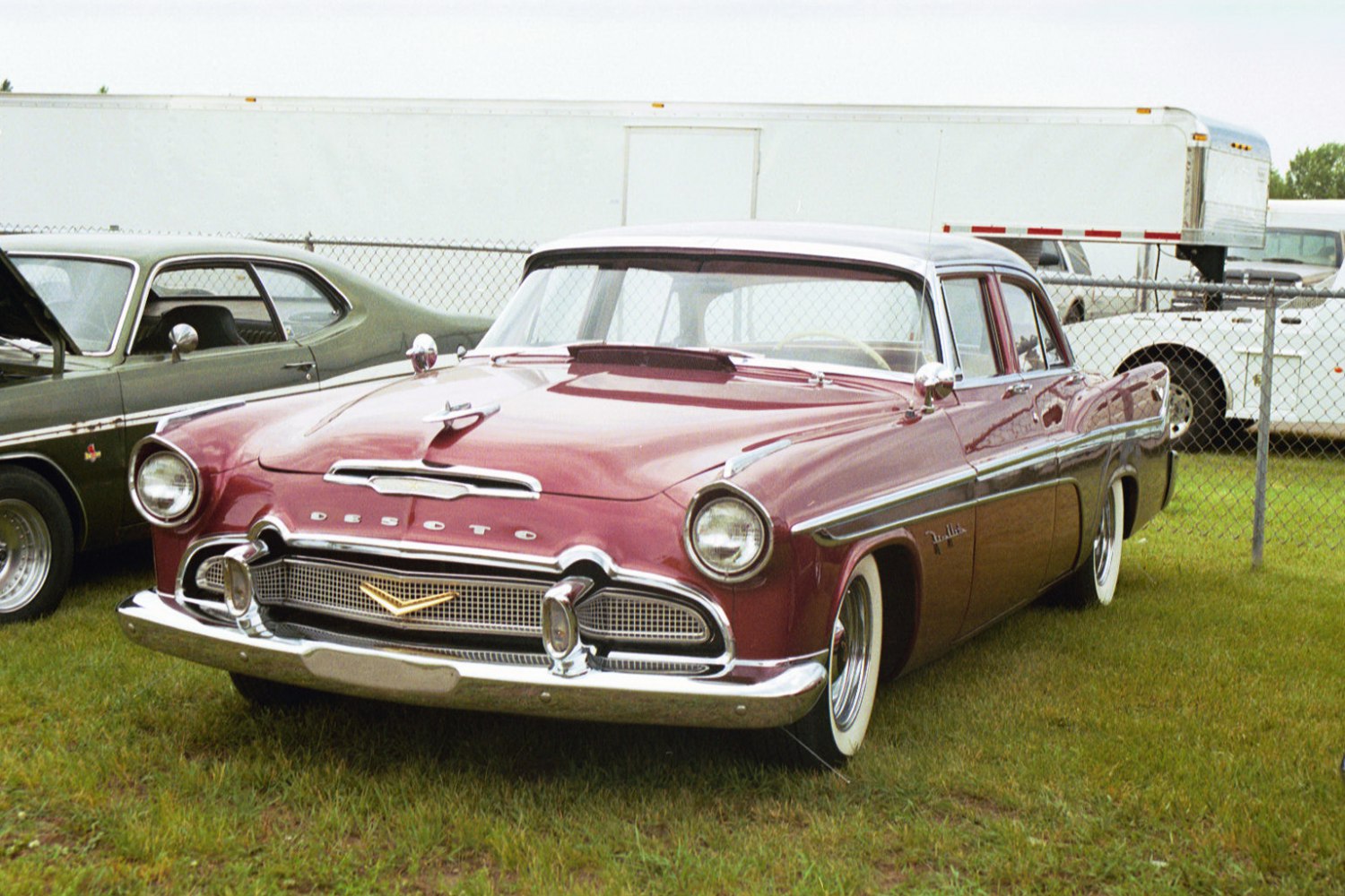 Wide chrome grille, hood ornament, round headlights, whitewall tires.