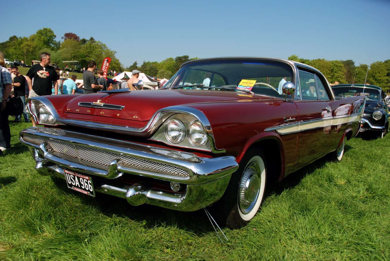 Classic 1950s car front and side with dual headlights and chrome details.