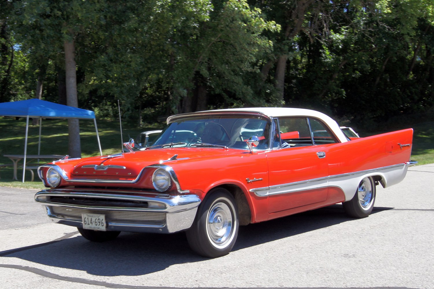 Two-door hardtop with distinctive tailfins and chrome bumper in red and white.