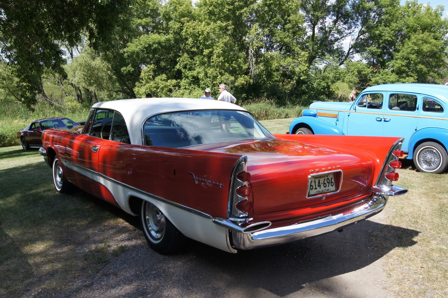 Vintage 2-door car with prominent tailfins and chrome bumper