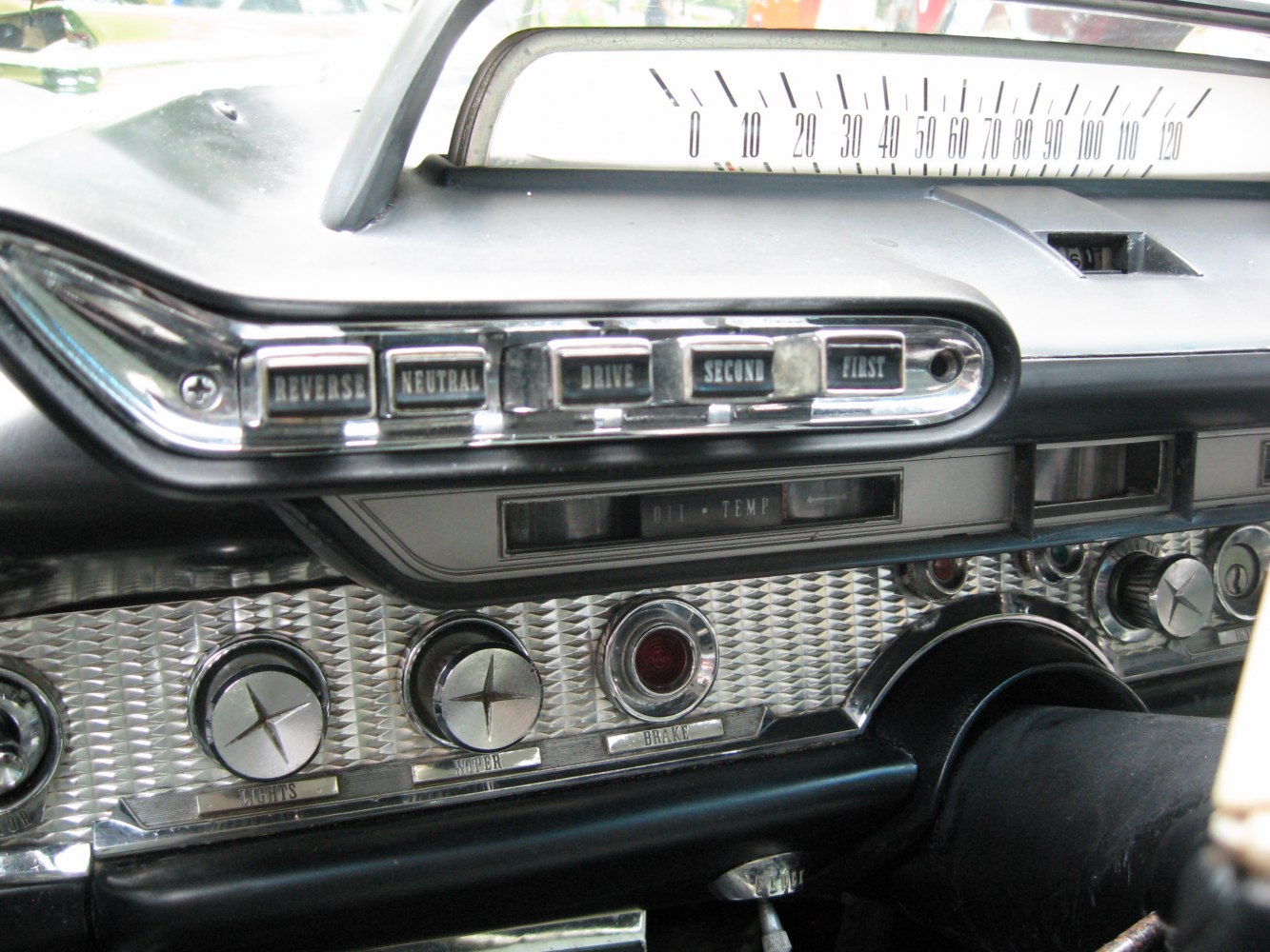 Vintage car dashboard with push-button transmission and classic gauges.