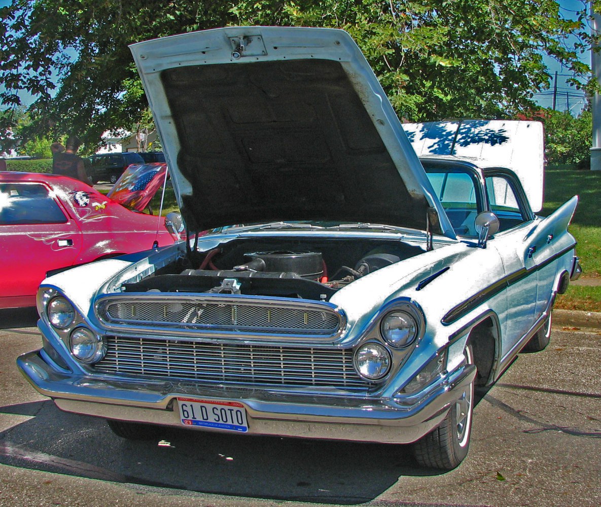 Front view of vintage car with open hood and dual headlights