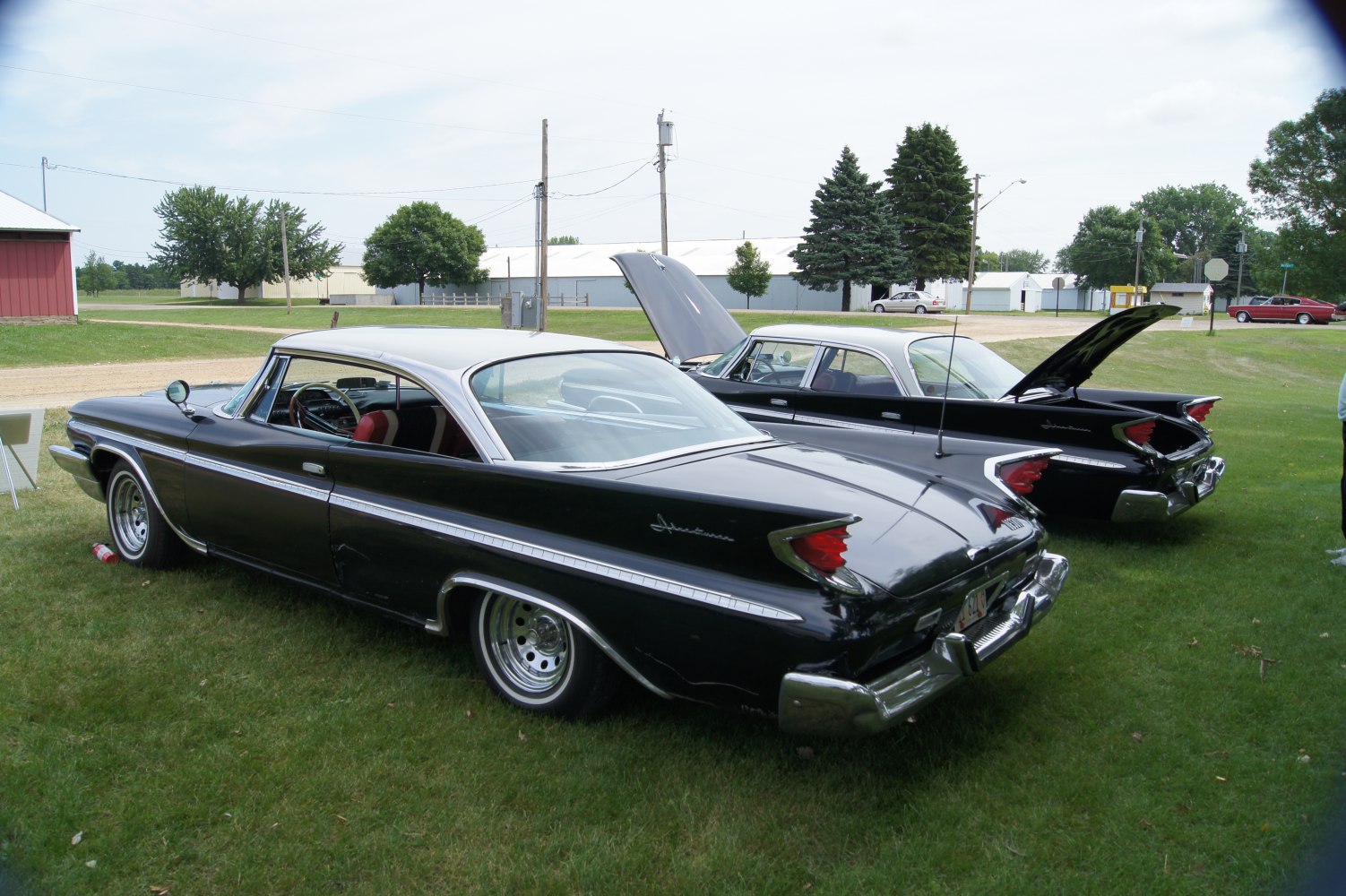Sharp rear tail fins and chrome-trimmed black-white hardtop coupe.
